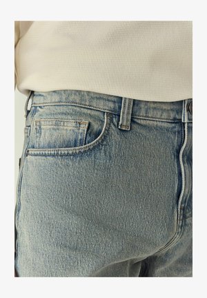 Lys blå denimjeans med et klassisk 5-lomme design, subtilt slid, en knaplukning og en let slidt tekstur.
