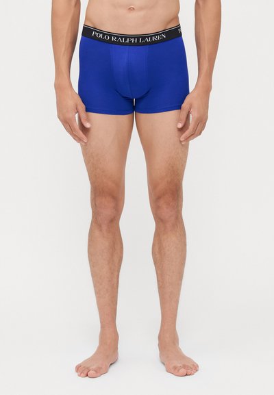 Modra bombažna bokserica z črnim pasom, ki nosi znak "POLO RALPH LAUREN". Prilagojen kroj, dolžina do sredine stegna, gladka tekstura.