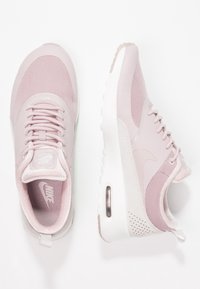 Růžové tenisky Nike vyrobené z mesh a semišových materiálů, s kulatou špičkou, šněrováním vpředu, viditelným vzduchovým polštářem a texturovanými detaily na patě.