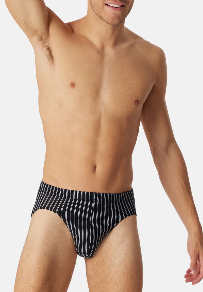 Caleçons pour hommes rayés noir et blanc avec une coupe ajustée et une ceinture élastique. Le tissu semble lisse avec un léger éclat.