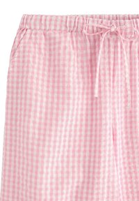 Pantaloni corti a quadri bianchi e rosa con elastico in vita e cordoncino da annodare, dotati di tasche laterali, su uno sfondo bianco.