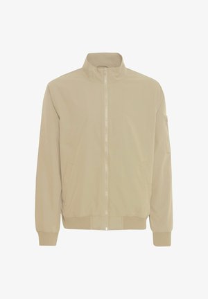 Giacca bomber beige con alta collarino, tasche laterali, polsini e orlo a coste. Tessuto liscio e zip frontale. Dettaglio della tasca sul braccio sinistro.