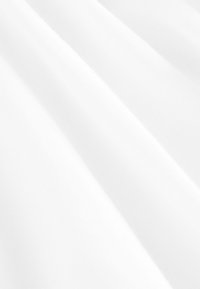 Witte stof getoond in zachte plooien, met een gladde textuur en subtiele glans, een fijne weave en zonder zichtbare patronen of accenten.