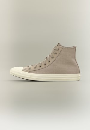 Baskets montantes en toile beige avec semelle et embout en caoutchouc blanc, vues de côté sur fond neutre.