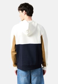 Felpa con cappuccio caratterizzata da blocchi di colore bianco, blu navy e marrone. Texture morbida con tasca a marsupio e orlo a costine; design dal fitting rilassato.
