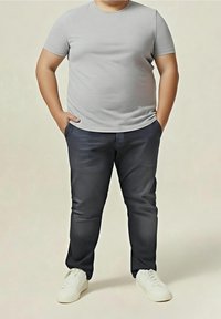 Šedé tričko s krátkým rukávem v kombinaci s tmavě modrými džíny a bílými teniskami. Oblečení má jednoduchý, ležérní design bez ozdob.