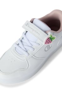 Białe sneakersy z gładką syntetyczną cholewką, pastelowym różowym wykończeniem, białą siateczkową językiem i akcentem w kształcie truskawki na pasku.