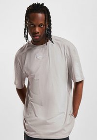 Gray short-sleeve t-shirt with round neck, featuring white cursive embroidery on the chest and a relaxed fit. Smooth fabric texture.