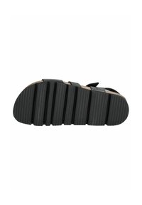 Semelle de sandale noire avec un design texturé et strié. Profil plat avec plusieurs rainures pour une meilleure adhérence et une finition lisse sur les bords.