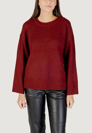Pullover in magenta con colletto rotondo e polsini a coste, caratterizzato da una vestibilità ampia e spacchi laterali. Abbinato a pantaloni in pelle neri.