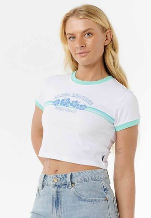 T-shirt blanc cropped avec des bordures bleu aqua, arborant des graphismes floraux et le texte "ALOHA BEACHES". Tissu lisse avec des manches courtes.