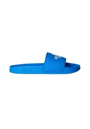Chancla azul hecha de material suave, con una cinta ancha y una suela texturizada. Logo blanco impreso en la cinta.