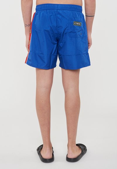 Shorts de bain bleus avec une taille élastique, ornés d'une rayure rouge sur le côté et d'une poche arrière avec le logo ICEBERG. Tissu lisse et léger.