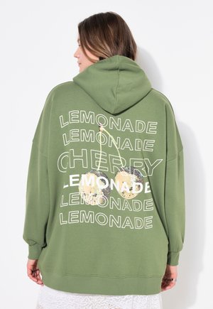 Vihreä ylisuuri huppari, jossa on kiristettävä huppu. Kuvassa on valkoista tekstiä "LEMONADE" ja "CHERRY" sekä disko21-lamppukuvasto.