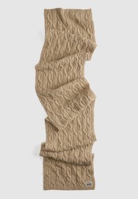 Knit scarf in beige wool, featuring a textured cable pattern, finished with a ribbed edge and a small label at the bottom corner.