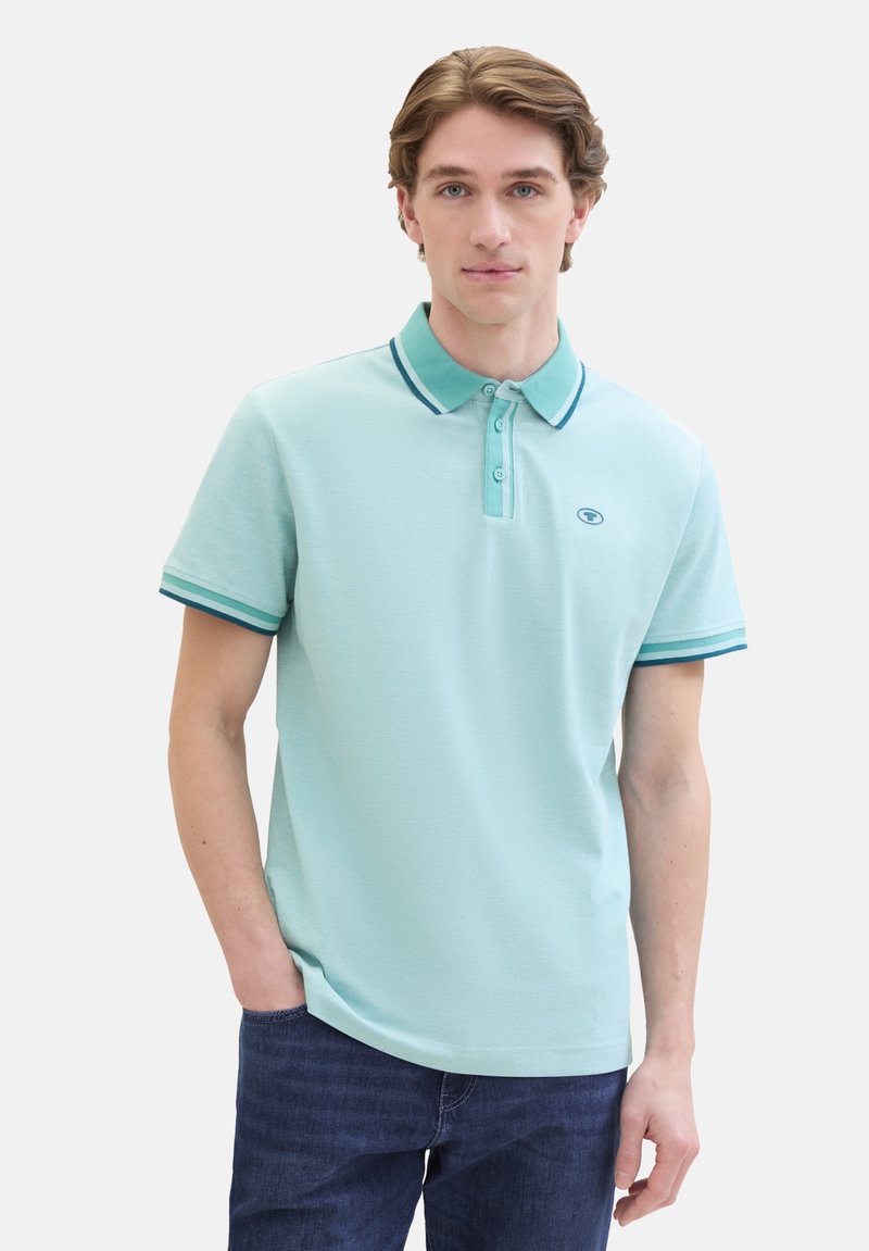 Lichtblauwe polo-shirt van textiel met structuur. Bevat een drieknoopsluiting, contrasterende kraag en mouwstrepen, en een geborduurd logo.