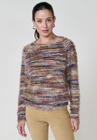 Mehrfarbiger, flauschiger Pullover mit Rundhalsausschnitt, der ein gestreiftes Design in Brauntönen, Blau und Gelb aufweist und eine weiche Textur hat.