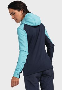 Kapuzenshirt mit einem strukturierten hellblauen oberen Abschnitt und einem dunkelblauen unteren Abschnitt. Verfügt über lange Ärmel und ein schlankes Design.