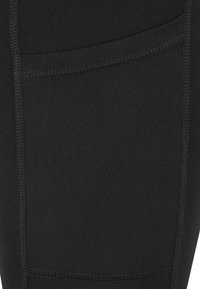 Leggings deportivos negros, con una tela suave y elástica, costuras planas y un bolsillo lateral para almacenamiento.