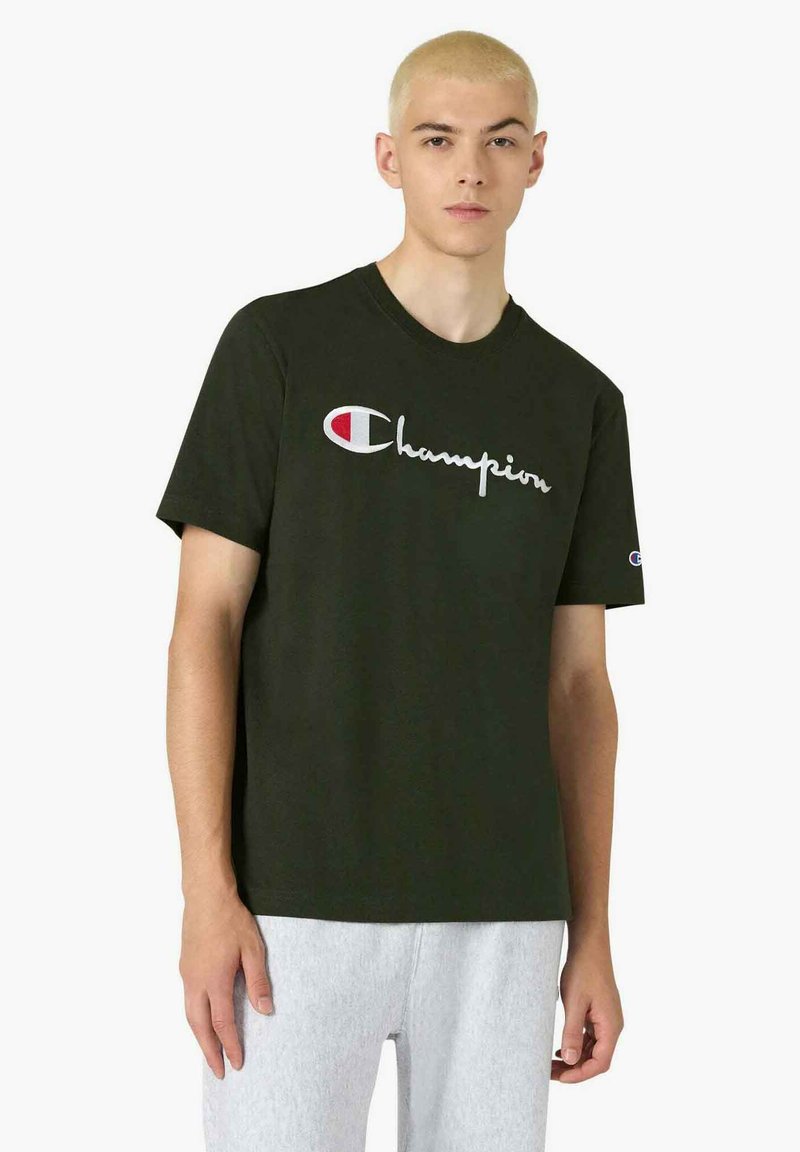 T-shirt in cotone verde scuro con il logo "Champion" bianco. Maniche corte e design classico con scollo rotondo. Tessuto strutturato con accenti sobri.