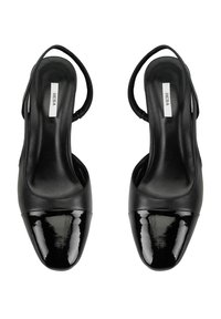 Chaussures à talons noirs à bride, avec un dessus en cuir lisse et un embout en cuir verni brillant. Comprend une semelle intérieure rembourrée et un talon élancé.