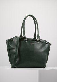 Ciemnozielona skórzana torba na ramię z dwoma uchwytami, paskiem na ramię oraz małym metalowym logo z przodu, wyeksponowana na białej powierzchni.