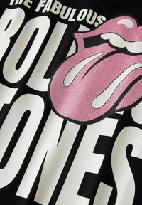 Black fabric with bold white text "THE FABULOUS ROLLING STONES" and a large pink glittery tongue logo overlapping the text.