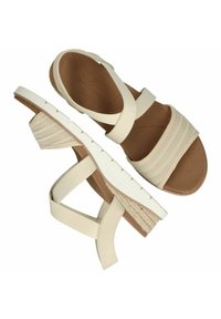 Sandalias beige con correas elásticas anchas y una plantilla texturizada. El tacón cuña es de color crema con un detalle trenzado en la parte posterior.