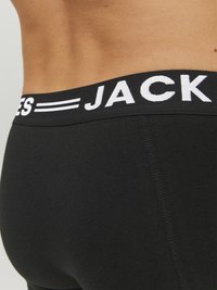 Schwarze Boxershorts mit einem weichen Bund, der mit weißen "JACK" Buchstaben versehen ist. Glattes Material mit enganliegendem Schnitt und sichtbaren Nähten.