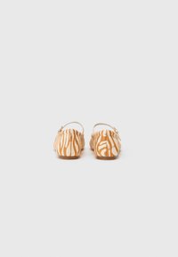 Zebra print slingback shoes in orange and cream, with a soft texture and flat soles, featuring a small ankle strap for secure fit.