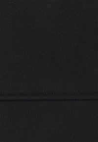 Musta ribbattu kangas, jossa on sileä tekstuuri, vaakasuorilla viivoilla ja saumattomalla designilla. Ei näkyvää varustusta tai koristeita.