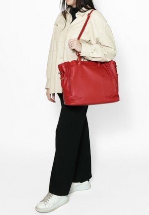 Rode leren handtas met twee handvatten bovenaan en een afneembare schouderband. Gladde textuur, ruime body en subtiele accentdetails.