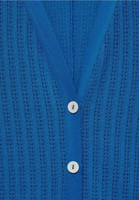 Cardigan bleu tricoté avec un motif perforé vertical et deux boutons blancs au centre devant.
