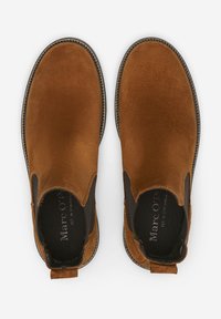 Bottines Chelsea en daim marron avec panneaux élastiques sur les côtés, bout arrondi, couture contrastante et semelle en caoutchouc texturée.