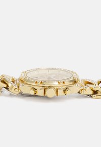 Montre chronographe dorée avec accents en cristal, couronne texturée et maillons. Cadran rond avec aiguilles dorées sur un fond contrastant.