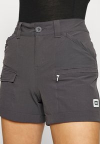 Gray outdoor shorts made from lightweight fabric, featuring a button closure, front pockets, and a zipped side pocket with logo detail.