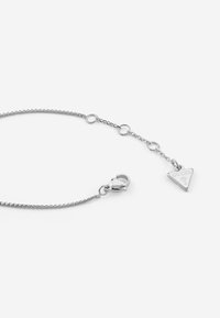 Bracciale in catena d'argento con pendente triangolare che presenta la incisione "GUESS" e una chiusura a moschettone. Design semplice ed elegante.