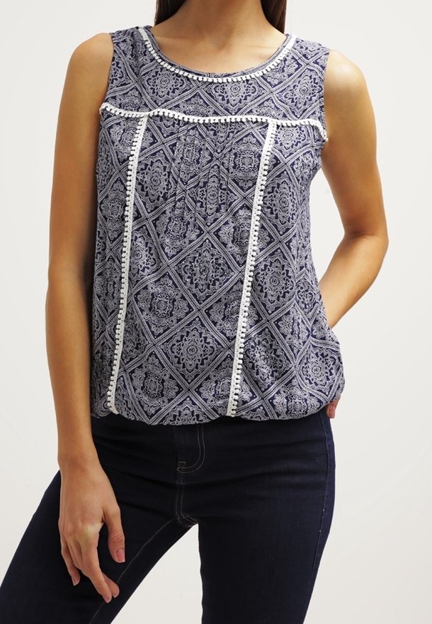 Ärmklänning i marinblått med geometriska vita mönster, med en texturerad bodice och spetskant längs halsringningen och mitten.