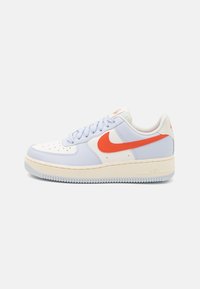 Baskets Nike Air Force 1 avec une tige en cuir bleu clair, un logo orange, des accents blancs et une semelle intermédiaire texturée avec un amorti Air proéminent.