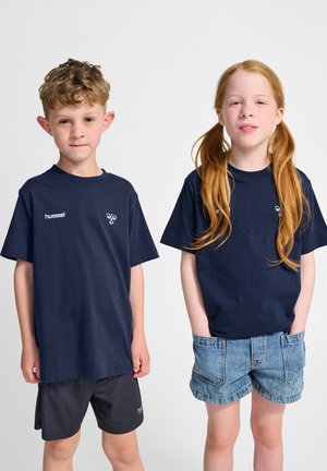 Mørkeblå bomuld t-shirts med korte ærmer, med et logo på venstre bryst; dreng iført sorte shorts, pige iført cowboyshorts.