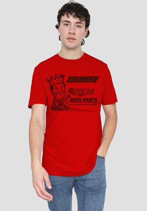 Rotes Baumwoll-T-Shirt mit einem schwarzen Grafikdruck eines Cartoon-Königs und dem Text "Zalinsky der König der Autoteile" in fetten Buchstaben.