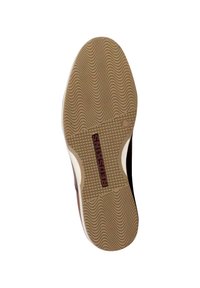 Semelle de chaussure avec un motif de texture ondulée. Couleur fauve avec un logo marron indiquant "REDSKINS" dans une zone de grille rectangulaire. Bords lisses et arrondis.