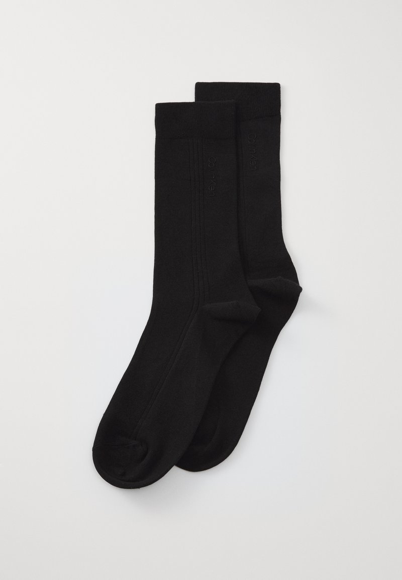 Ciorapi negri dintr-un material neted și elastic. Prezintă un design cu nervuri în partea de sus și un branding subtil pe lateral. Cusătură plată la degete.