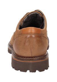 Scarpa in pelle marrone con finitura liscia, forma arrotondata, suola in gomma resistente e dettagli di cucitura a contrasto lungo i bordi.