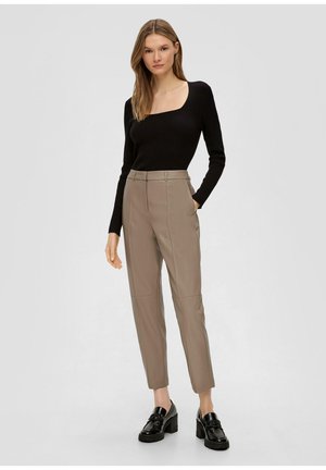 Czarna, prążkowana bluzka z długim rękawem w połączeniu z beżowymi spodniami o kroju tailored z bocznymi kieszeniami, slim fit oraz eleganckimi czarnymi mokasynami na masywnym obcasie.