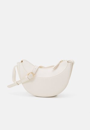 Sac bandoulière en cuir couleur crème en forme de croissant avec sangle réglable et boucle dorée, fermeture éclair sur le dessus.