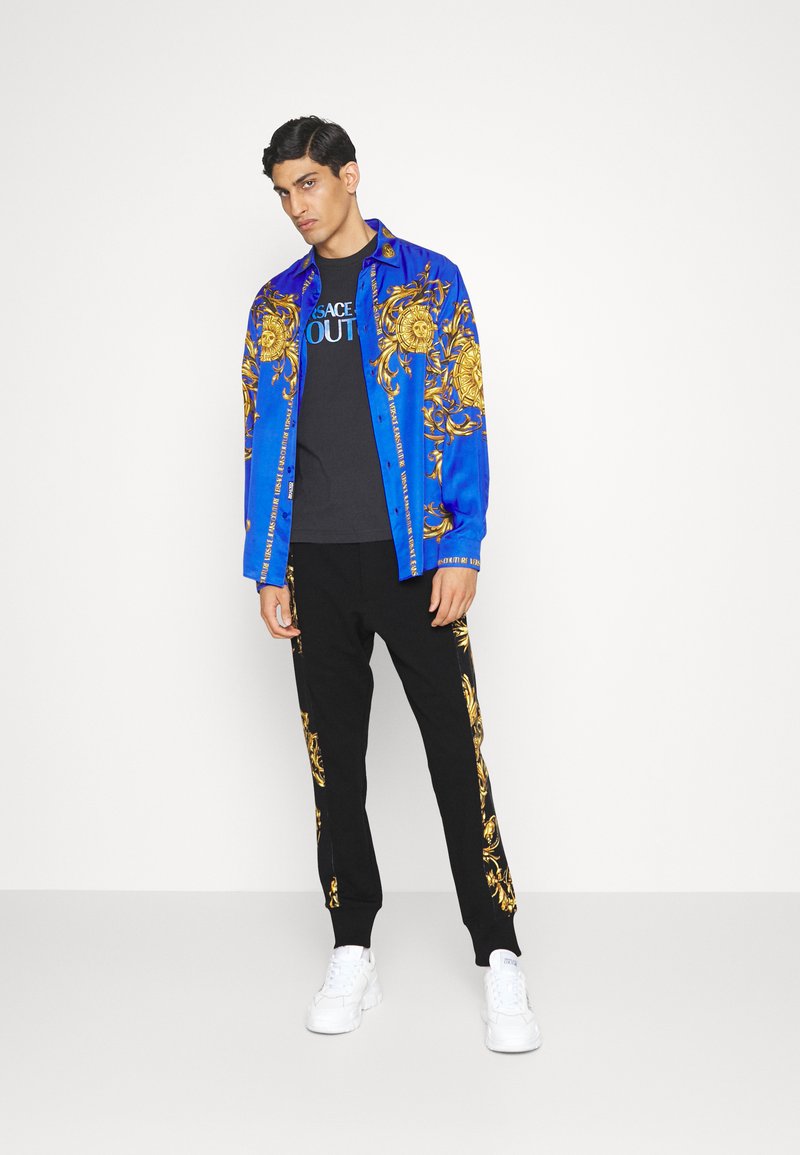 Herren Trainingsanzüge | Versace Jeans Couture GARLAND Jogginghose black/schwarz - WS26341 Herren Trainingsanzüge | Versace Jeans Couture GARLAND Jogginghose black/schwarz - WS26341