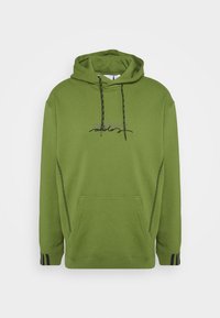 Grön huvtröja gjord av bomullsblandningsmaterial. Har svarta snören, en framficka och svarta randiga detaljer på muddar.