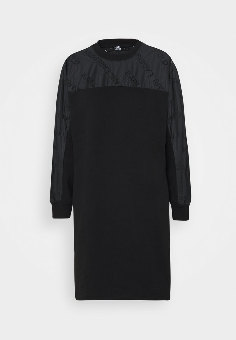 Schwarzes Kleid mit langen Ärmeln, ausgestattet mit einem strukturierten oberen Abschnitt und einem weichen Baumwollkörper. Die Ärmel besitzen ein dezentes Logo-Muster.