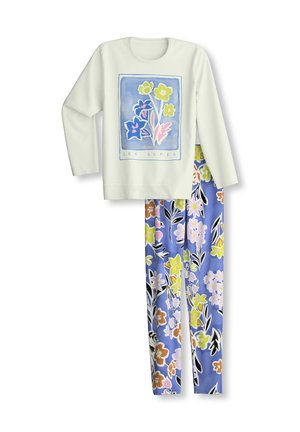 Haut blanc à manches longues avec imprimé floral et texte "Les Alpes", assorti à un pantalon de pyjama bleu à motifs floraux.
